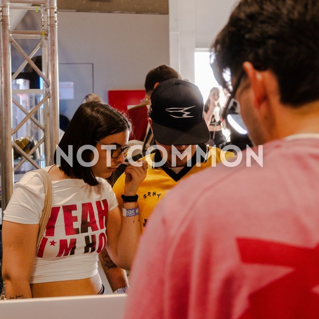 Chica oliendo perfume VELVYX en feria de streetwear